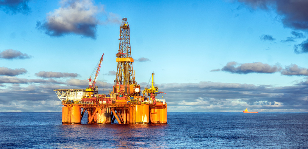 Photo of an shipping tanker and oil rig at sea