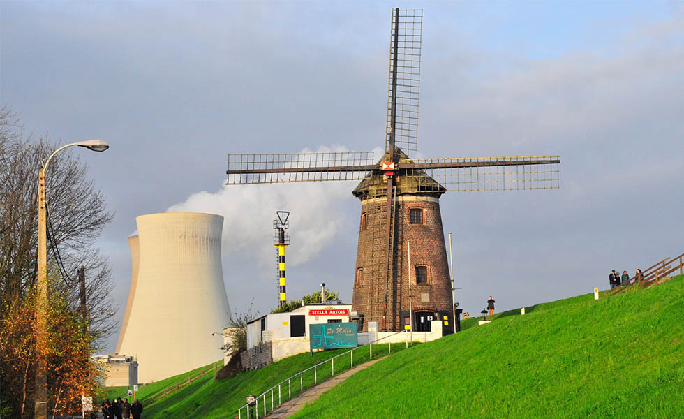 Photo Cooling towers behind a windmill